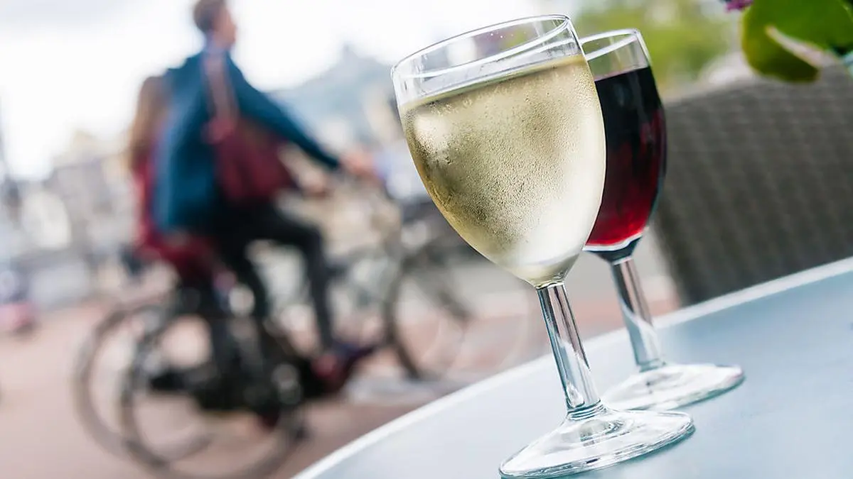 Glasses of white and red wine on a table outside a bar in Amsterdam