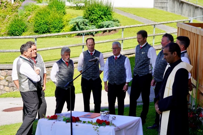 Die Sängerrunde Irschen unter Chorleiter Stefan Wallner und Obmann Heimo Klocker umrahmt die Segnung, die Pfarrer Mario Polimetla vornimmt.