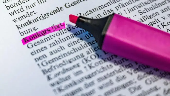 Rosa Textmarker, wobei das Wort Konkurs angestrichen wurde
