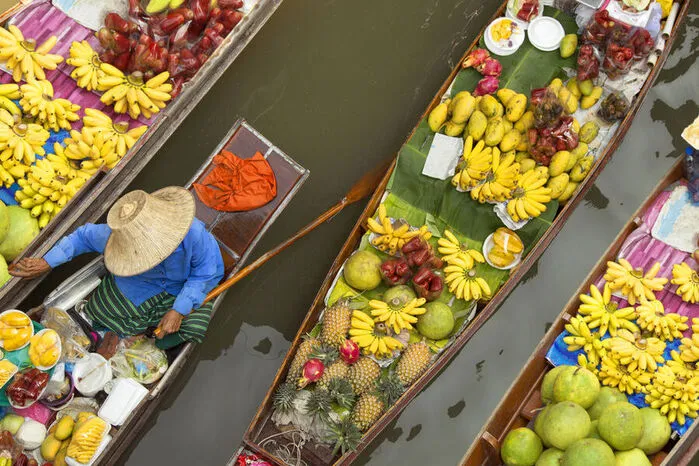 Am Damnoen Saduak Floating Market in der Nähe von Bangkok wird am Wasser gefeilscht. Zahlreiche Einheimische bieten dort Früchte, Gemüse und Teigwaren an.