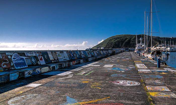 "Autogrammkarten" der Atlantiksegler an der Hafenmauer in Horta 