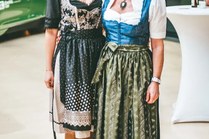 Katarina Gutmann in einer eleganten Schwarz-Gold-Kombination und Barbara Hirschberger in traditionell-grüner Tracht.