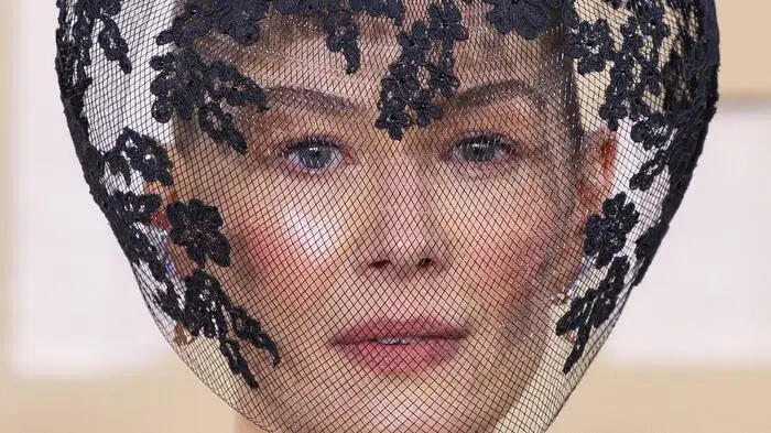 Schauspielerin Rosamund Pike hatte am roten Teppich der Golden Globes wohl eines der schrägsten Outfits. Der „Saltburn“-Star entschied sich für ein schlichtes, spitzenbesetztes schwarzes Kleid. Dazu kombinierte 44-Jährige den passenden Kopfschmuck. Der Spitzenschleier verhüllte einen Großteil ihres Gesichtes. Der Hintergrund: Pike hatte rund um Weihnachten einen Skiunfall und hätte sich ihr Gesicht „völlig zertrümmert“, wie sie im Interview mit „Variety“ verriet. Um etwas von ihren Blutergüssen abzulenken, musste Pike kreativ werden.
