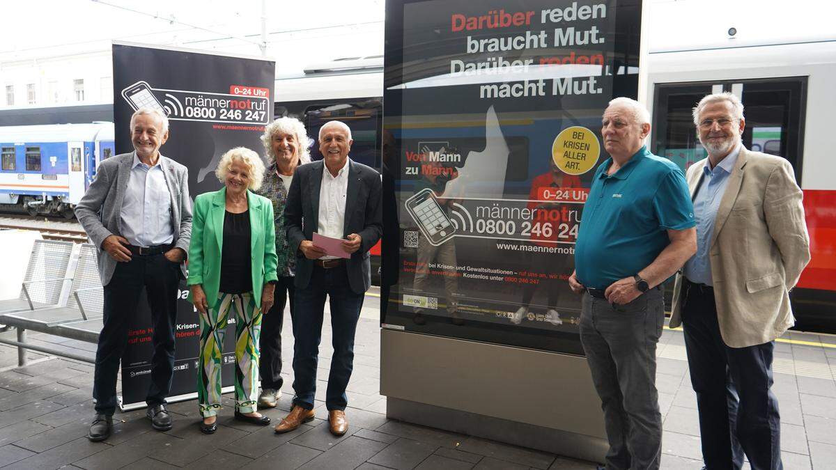 Mitarbeiter des Männernotrufs mit Leiter Eduard Hamedl und Chefsekretärin Erika Hausberger vor dem Plakat der neuen Infokampagne