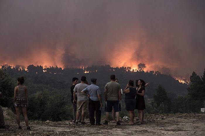 Menschen beobachten, wie sich die Flammen Monchique nähern
