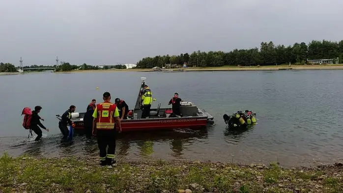 Ein Team aus Wasserrettern steigt am Ufer des Schwarzlsees in ein Boot