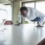 Senior businessman doing push-ups on desk in office model released, Symbolfoto property released, UUF30708