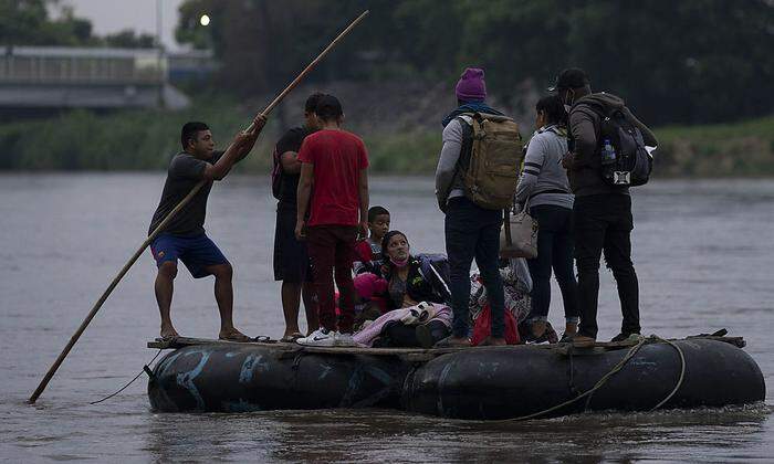 Migranten überqueren den Grenzfluss