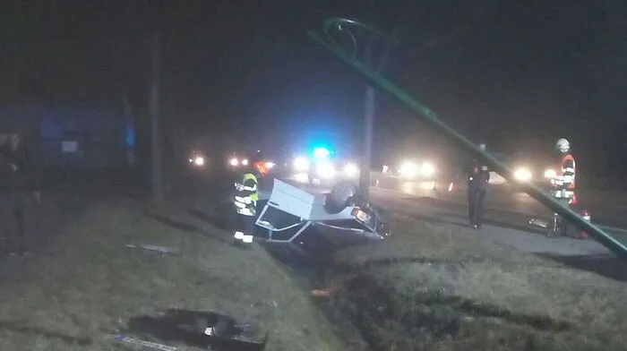 Unfallfahrzeug und geknickte Straßenlaterne