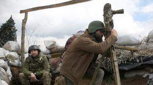 Ein ukrainischer Soldat blickt an der ostukrainischen Front mit den von Russland unterstützten Separatisten durch ein Periskop