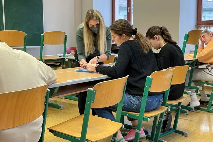 Im Mathematik-Unterricht erklärt eine Lehrerin ihr die Aufgaben.