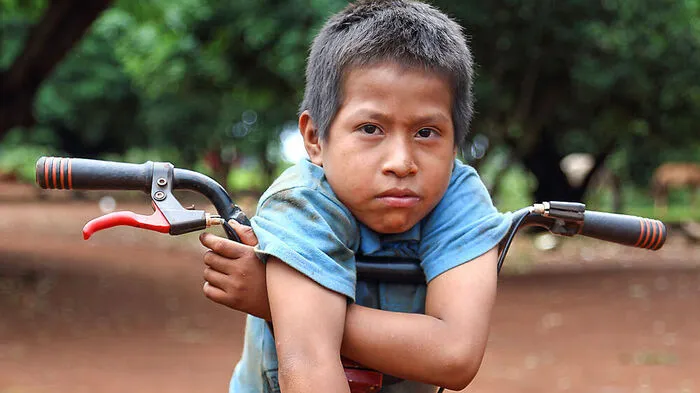 Ein Bub der Guarani auf seinem Rad 