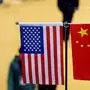 (FILES) This file picture taken on November 6, 2018 shows a Chinese and US flag at a booth during the first China International Import Expo  in Shanghai. - US President Donald Trump ripped into China on July 30, 2019 after US negotiators arrived in Shanghai to resurrect talks aimed at ending a year-long trade war between the world's two top economies. Trump took to Twitter to slam China hours after top US officials landed in the financial hub for the first face-to-face discussions since the US leader agreed to a trade war truce with Chinese President Xi Jinping in June. (Photo by Johannes EISELE / AFP)
