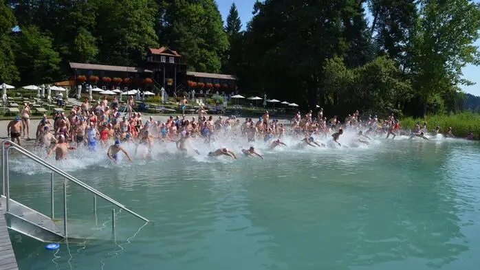 Mehrere Personen laufen in einen See