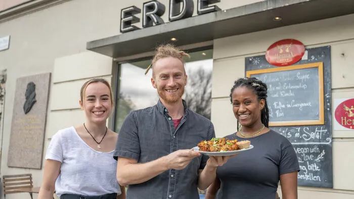 Thomas Schnölzers Café Erde wurde schon 2012 als rein veganes Lokal am Andreas-Hofer-Platz eröffnet. Mit den Mitarbeiterinnen Theresa Neugebauer und Mirjam Helminger zeigt er hier ein Mittagsgericht: Asia-Puffer mit Kimchi und Erdnusssoße