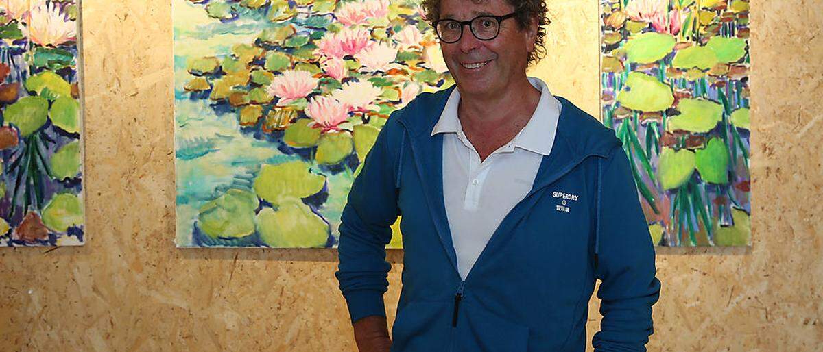 Der Arzt und Maler Harald Scheicher vor drei Seerosen-Bildern, die erst jüngst entstanden sind