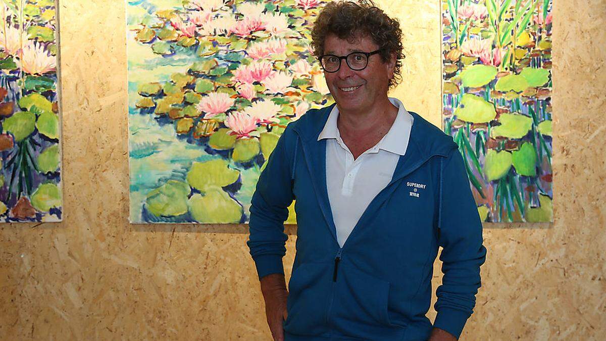 Der Arzt und Maler Harald Scheicher vor drei Seerosen-Bildern, die erst jüngst entstanden sind