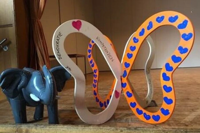 Baby-Elefant und Demokratiekompetenzenschmetterling - zwei Symbole mit Aussagewert