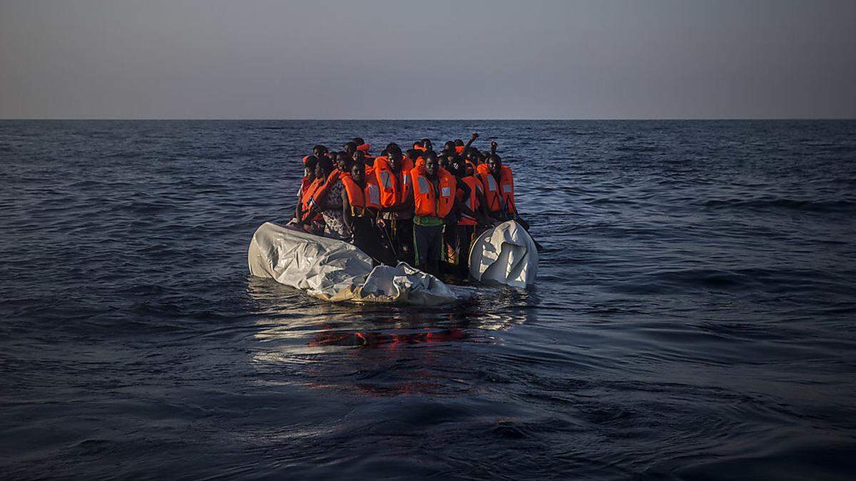 Flüchtlinge in einem halb versunkenen Schlauchboot