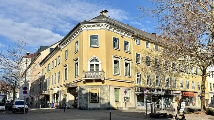 Blick auf ein großes gelbes Eckhaus in einer Innenstadt