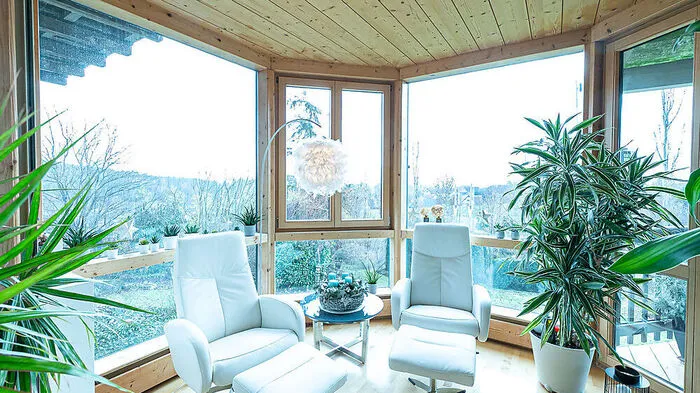 Im offenen Wintergarten laden gemütliche Sessel ein, die Sonnenstrahlen zu genießen.