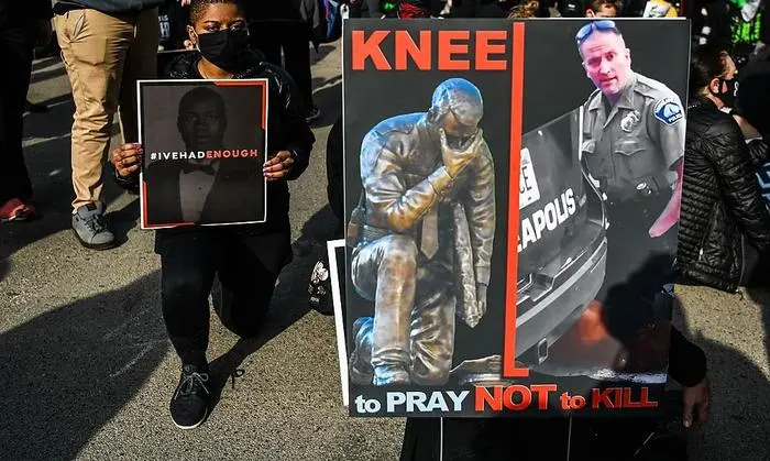 Derek Chauvin rechts auf dem Plakat eines Demonstranten