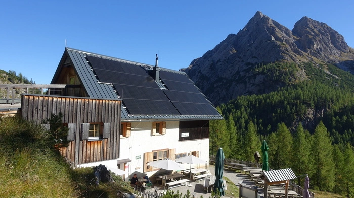 Das Schutzhaus auf der Kerschbaumeralm. Im Hintergrund erhebt sich ein Berggipfel der Lienzer Dolomiten
