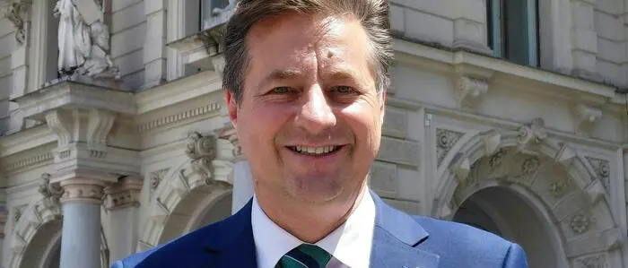 René Apfelknab in Anzug und Krawatte vor dem Grazer Rathaus