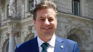 René Apfelknab in Anzug und Krawatte vor dem Grazer Rathaus