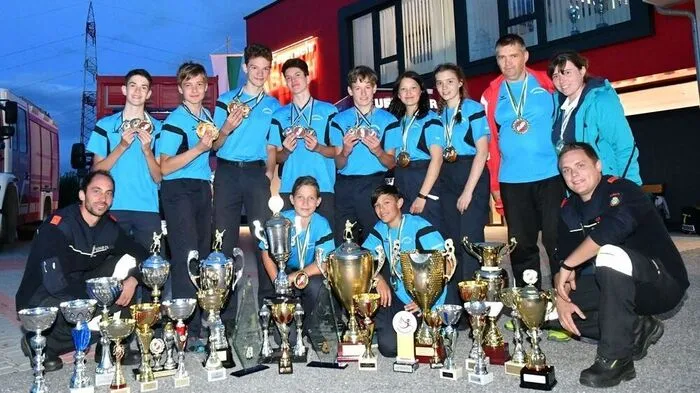 Ein Teil der erfolgreichen Jugendmannschaft mit ihren Betreuern und zahlreichen Trophäen