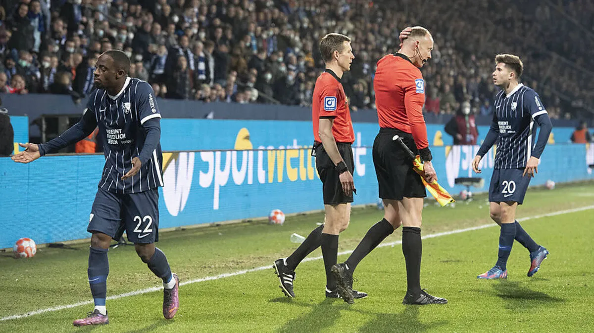 Schiedsrichter-Assisten Christian Gittelmann reibt sich nach dem Becherwurf den Kopf.