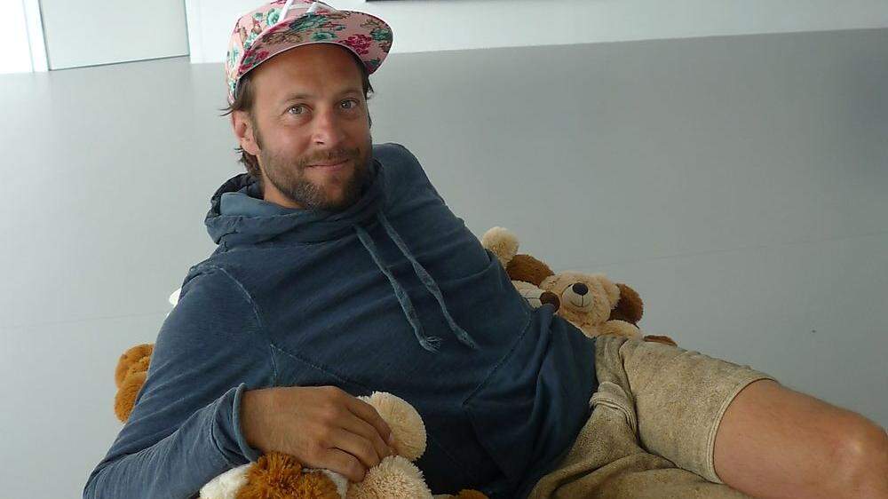 Clemens Gunzer auf Teddybären-Sofa.
