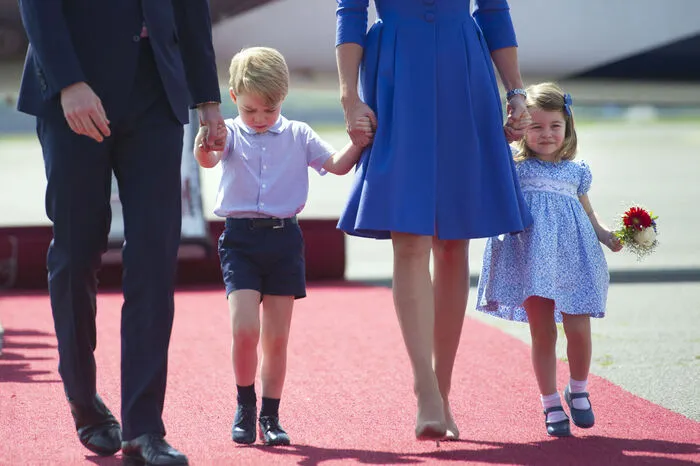 Bei der Ankunft am Flughafen Berlin-Tegel zeigten sich William und Kate zusammen mit ihren Kindern Prinz George und Prinzessin Charlotte, die Hand in Hand mit ihnen in kurzer Hose und Kurzarmhemd sowie einem hellblauen Kleidchen über den roten Teppich gingen.