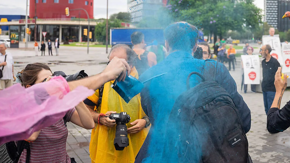 Ein Besucher der Immobilienmesse "The District" wird mit Farbpulver beworfen