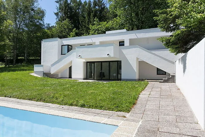 Zeitlose Eleganz à la Abraham. Zwei symmetrische Freitreppen führen von der Terrasse in den Garten mit Pool.