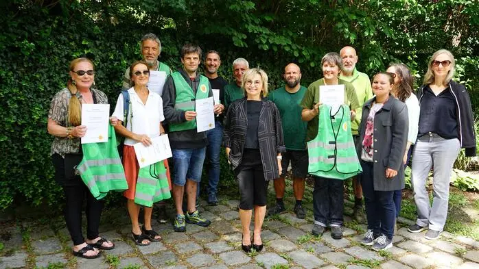 Eine Gruppe von Menschen mit Warnwesten und Urkunden
