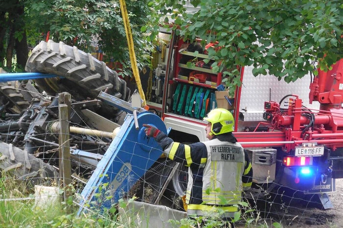 Aus unbekannter Ursache war ein Traktor bei Mäharbeiten umgekippt, der Fahrer konnte sich unverletzt aus der Fahrerkabine befreien.