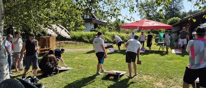 Spielsituation auf einer Wiese, zwei Männer spielen ein Geschicklichkeitsspiel