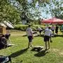 Spielsituation auf einer Wiese, zwei Männer spielen ein Geschicklichkeitsspiel