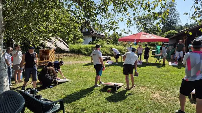 Spielsituation auf einer Wiese, zwei Männer spielen ein Geschicklichkeitsspiel