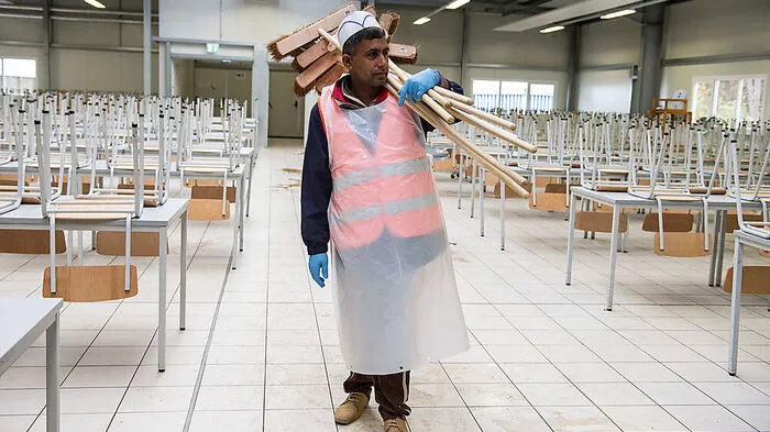 Ein Flüchtling bei der Reinigung einer Unterkunft in Baden-Württemberg 