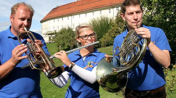 Obmann Norbert Stromberger, Musikerin Stephanie Gruber und Kapellmeister Heinz Gritzner vor dem Stift St. Georgen