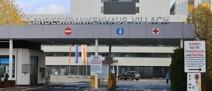 Außenansicht der Einfahrt eines Krankenhauses mit Schranken