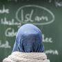 Junge Frau mit Kopftuch vor Tafel | Laut Memić zeigen sich kritische Einstellungen oft in Form von Fragen