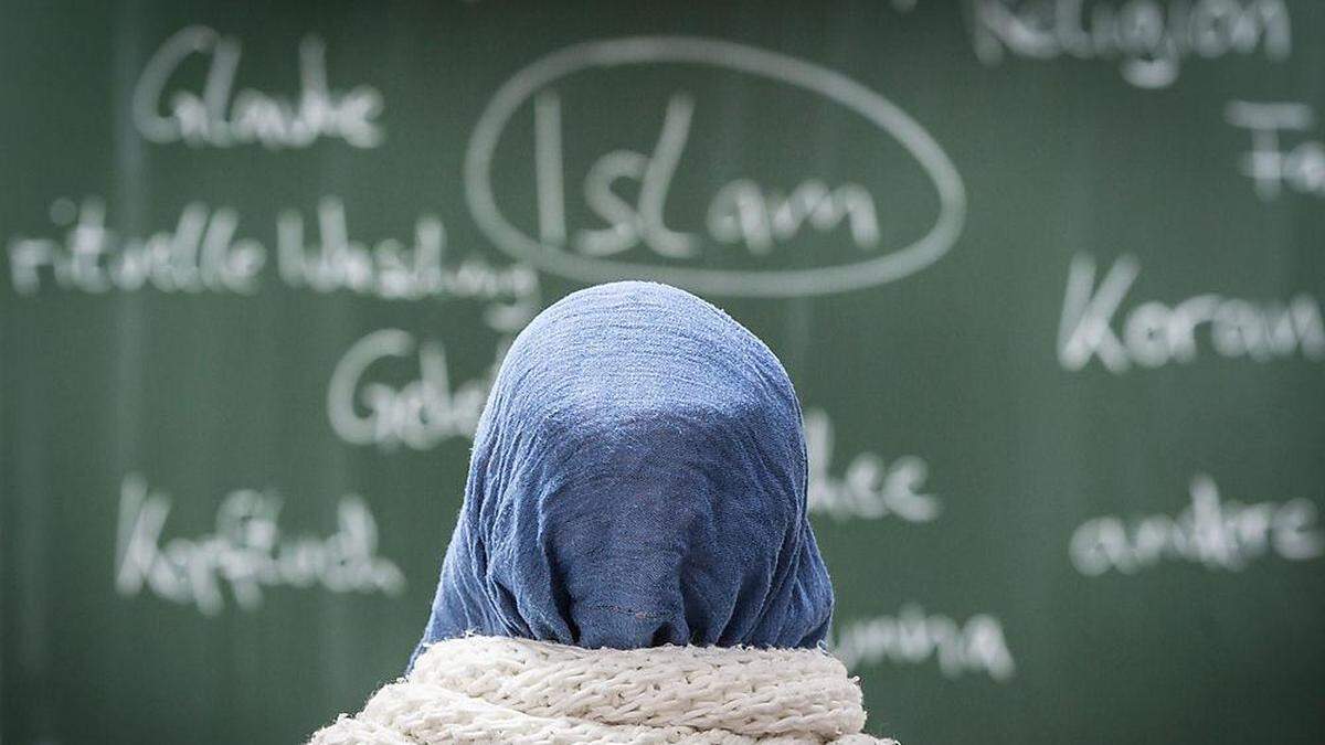 Junge Frau mit Kopftuch vor Tafel | Laut Memić zeigen sich kritische Einstellungen oft in Form von Fragen