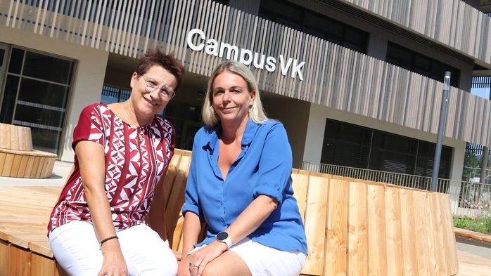 Zu sehen sind zwei Frauen vor einem neuen Schulgebäude