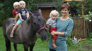 Katrin Grauf mit ihren eigenen Kindern Caspar und Anton (am Pferd) sowie Anselm auf ihrem Bauernhof "Sonnenhof in Goritschach in Gallizien 