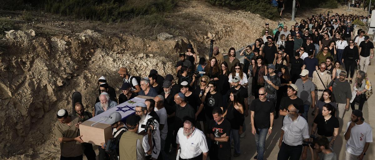 Trauergäste tragen den flaggenbedeckten Sarg der 22-jährigen Shani Louk bei der Beisetzung in Srigim, Israel