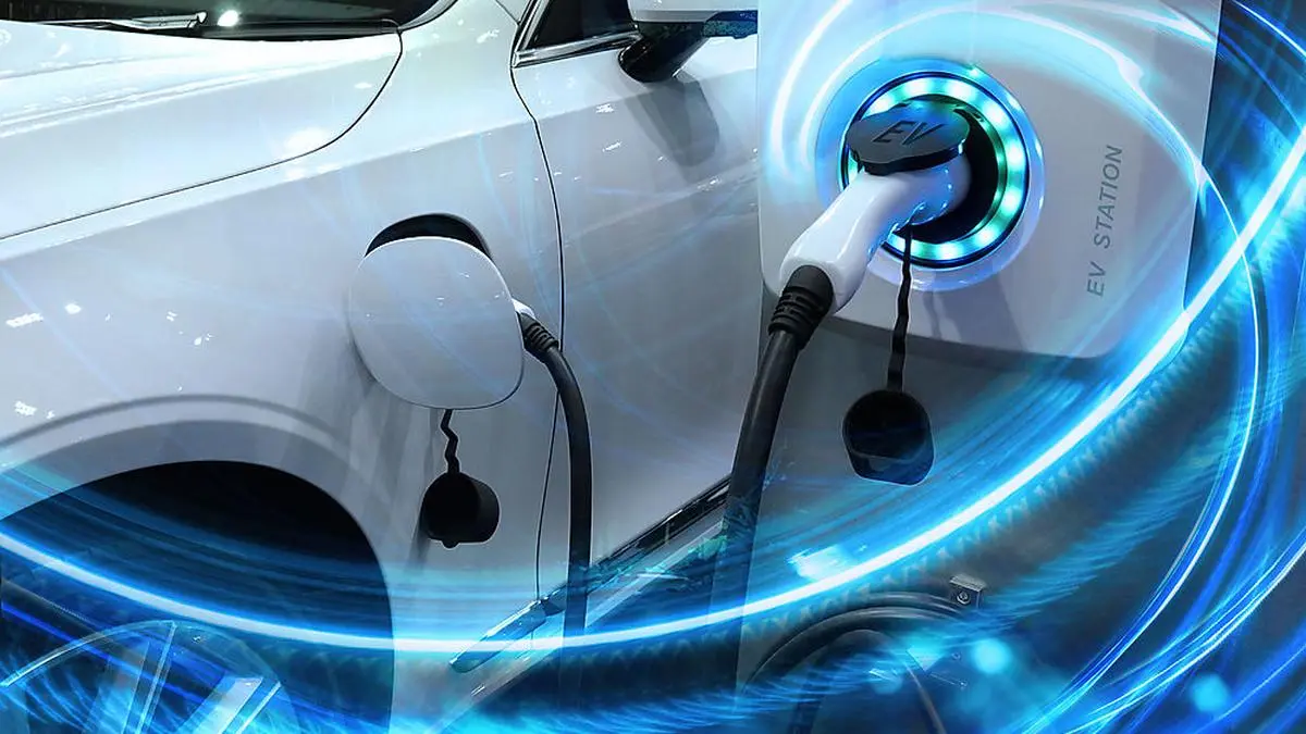 EV Car or Electric vehicle at charging station with the power cable supply plugged in on blurred nature with blue energy power effect. Eco-friendly sustainable energy concept.