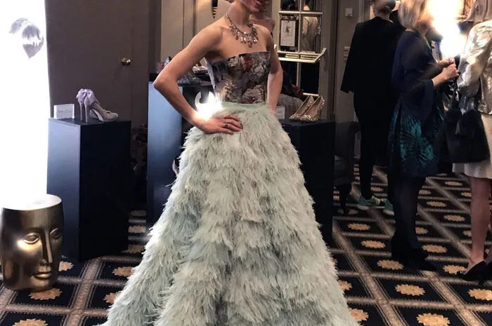 Ioanna Avraam, Solotänzerin der Wiener Staatsoper, hat sich für ein Signature Piece entschieden. Dem Federnrock in Mint kombiniert wird zu einer Jacquard Korsage aus Seide getragen. Das Oberteil ist mit Swarovskisteinen veredelt. Blumen und Rosen unterstreichen das Outfit.